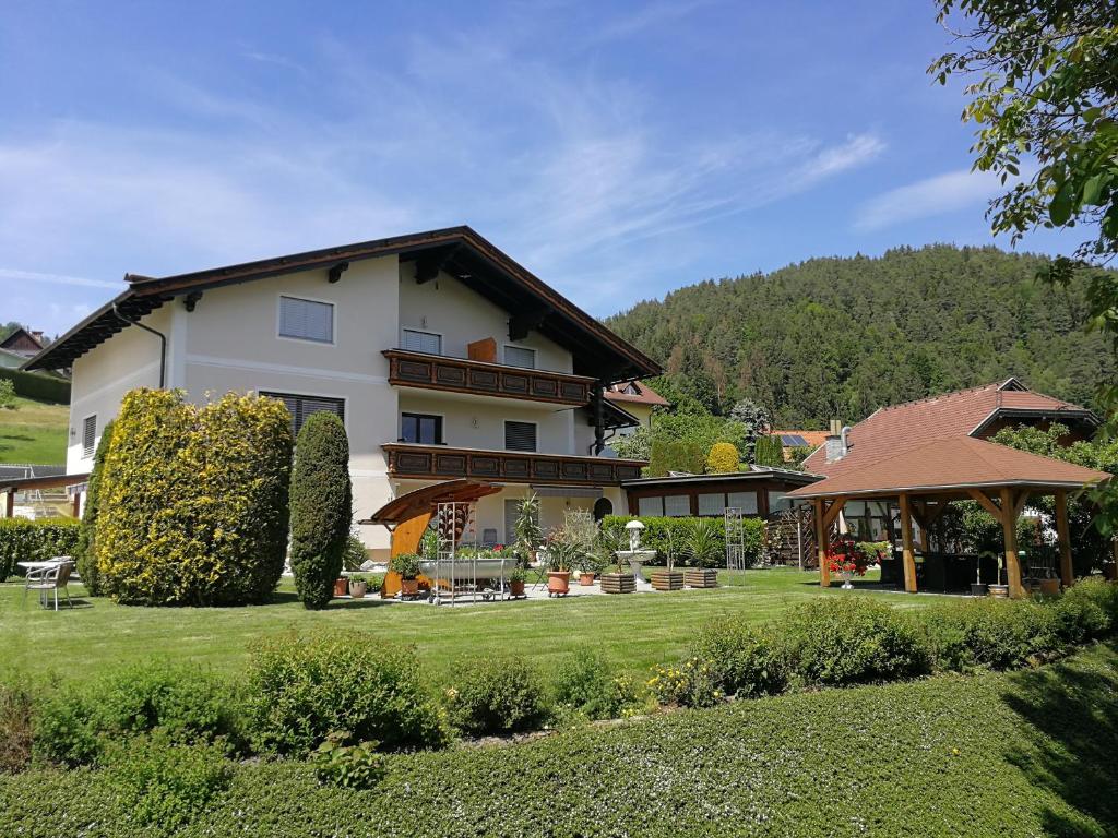 une grande maison blanche avec une grande cour dans l'établissement Ferienwohnungen Oranhof, à Velden am Wörther See