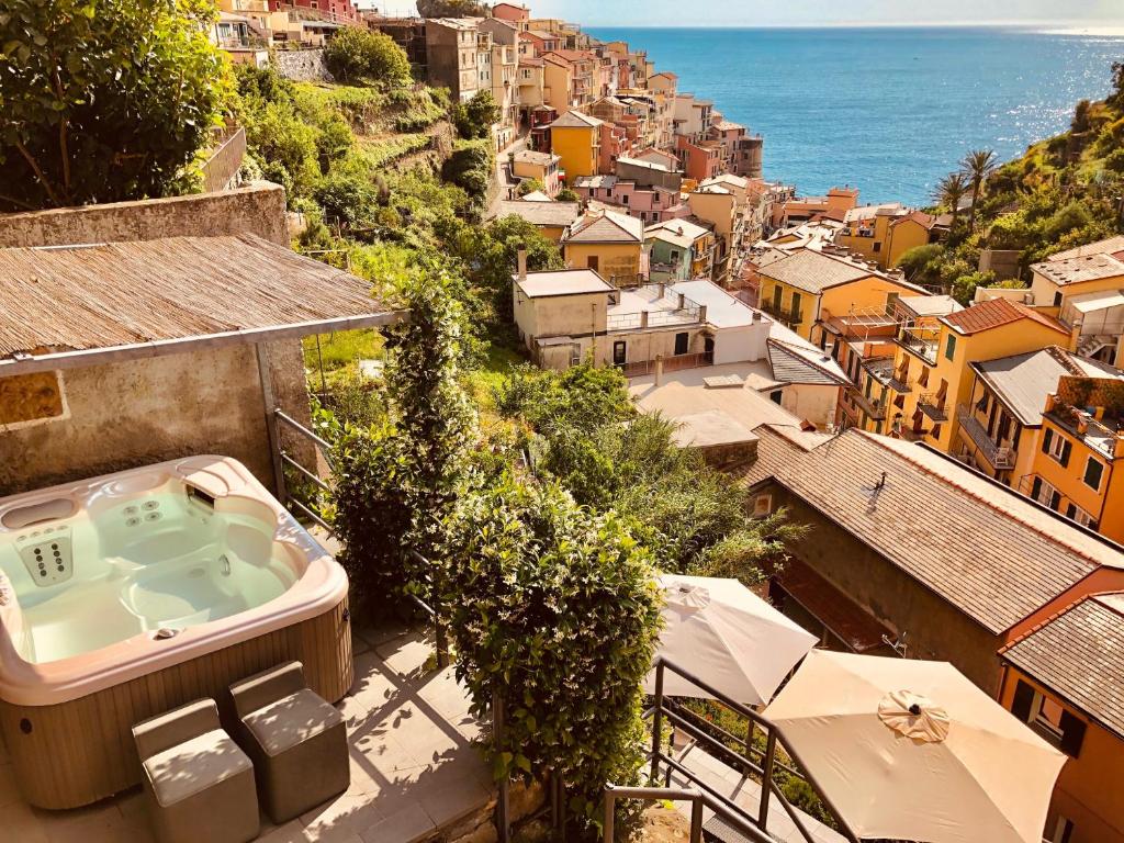 a hot tub on the side of a building next to the ocean at La Torretta Lodge in Manarola