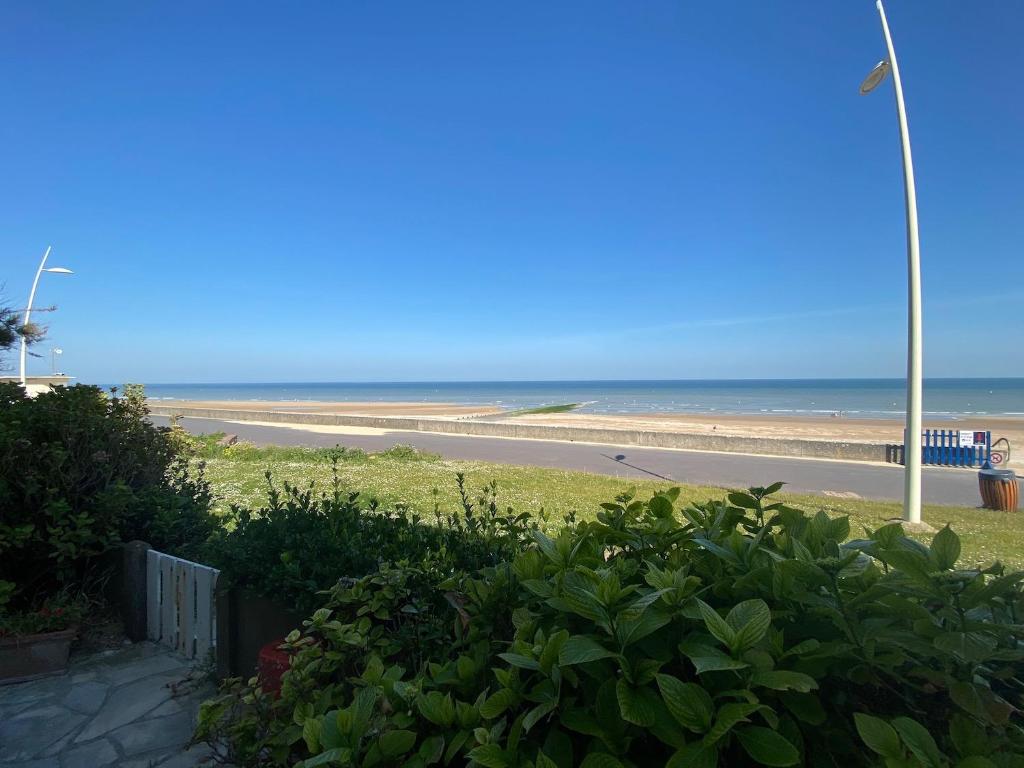 - une vue sur une plage avec une route et l'océan dans l'établissement 3 PIECES RESIDENCE CAP CABOURG Avenue Morimbaud à Cabourg, à Cabourg