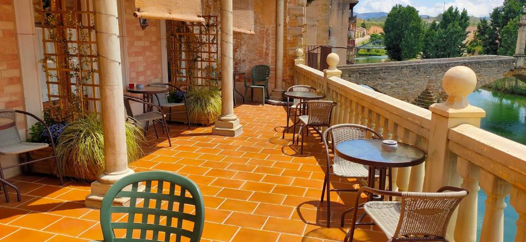 een patio met tafels en stoelen op een balkon bij Albergue Valderrobres in Valderrobres