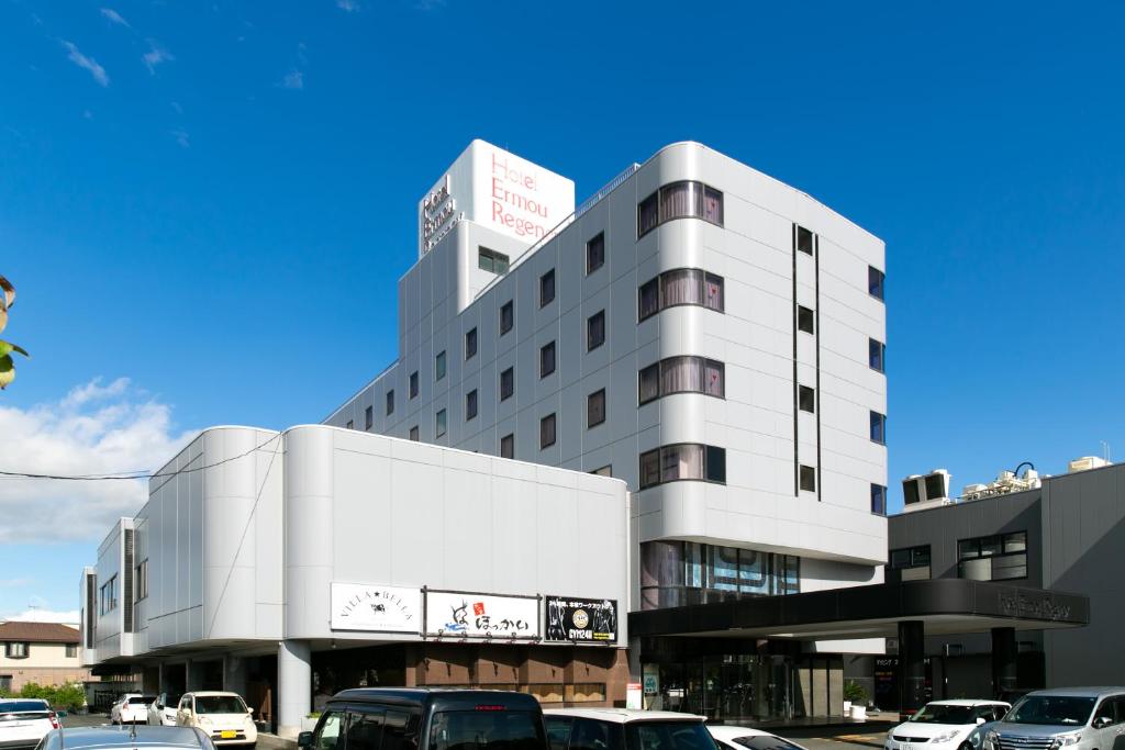 un edificio con auto parcheggiate in un parcheggio di Hotel Ermou Regency a Numazu