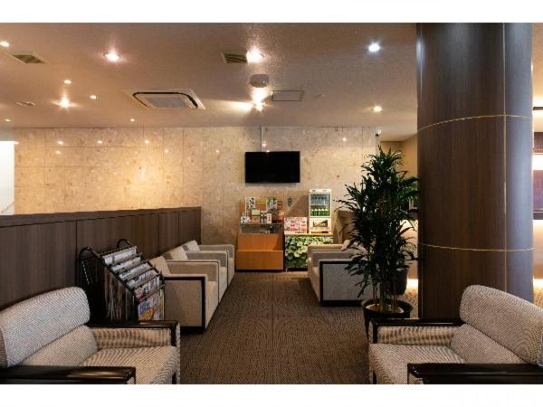 una hall con sala d'attesa con divani e TV di Hotel Ermou Regency a Numazu