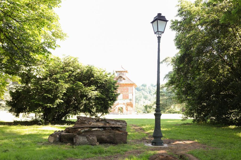 a lamp post in a park with a building in the background at La Maison du Saula in Lafrançaise