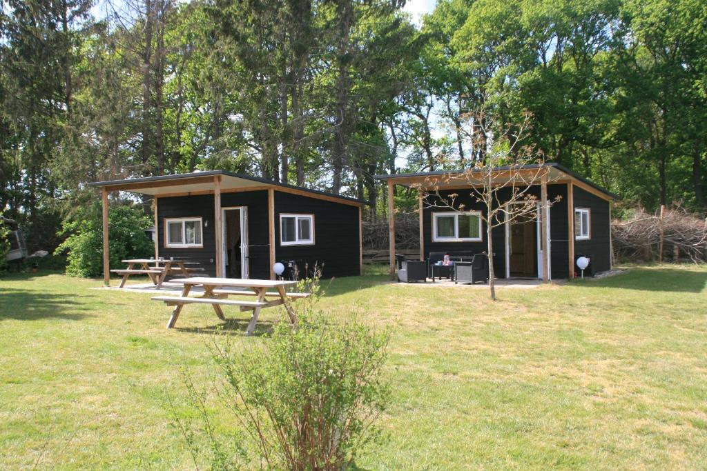 une petite cabine avec une table de pique-nique dans un champ dans l'établissement Trekkershut, à Beilen