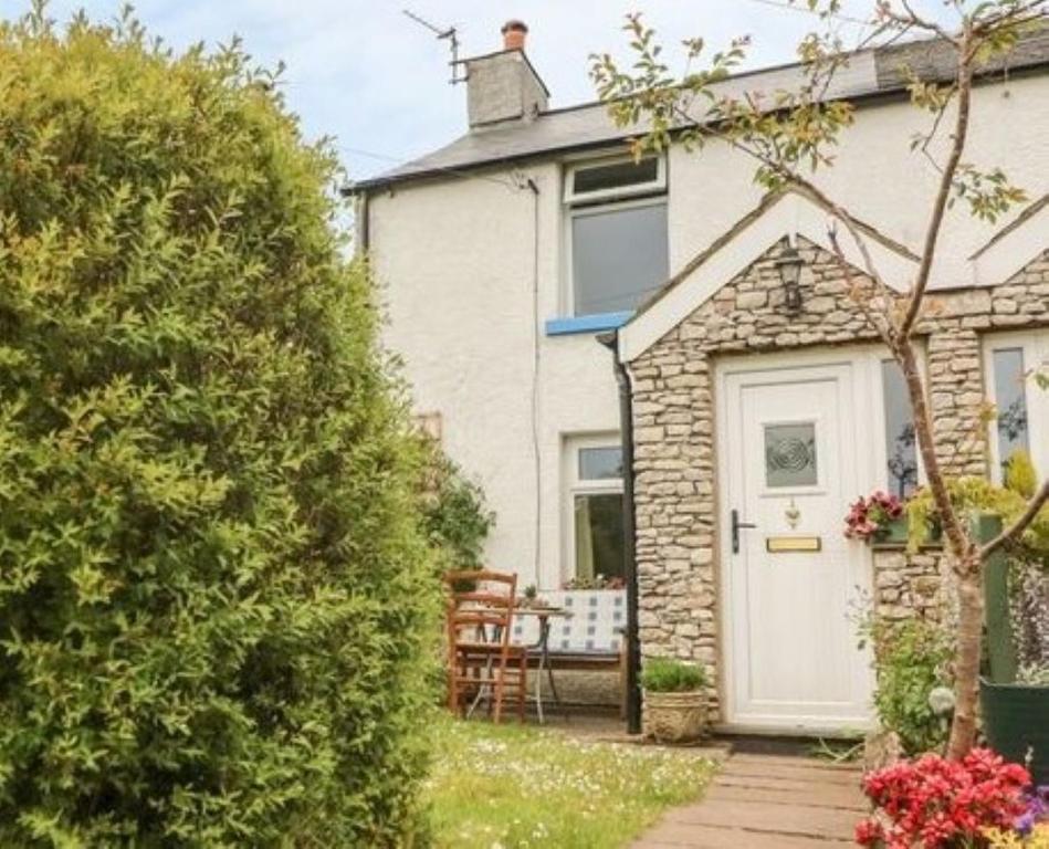 a house with a white door and a patio at Sunnybank Cottage in Ulverston
