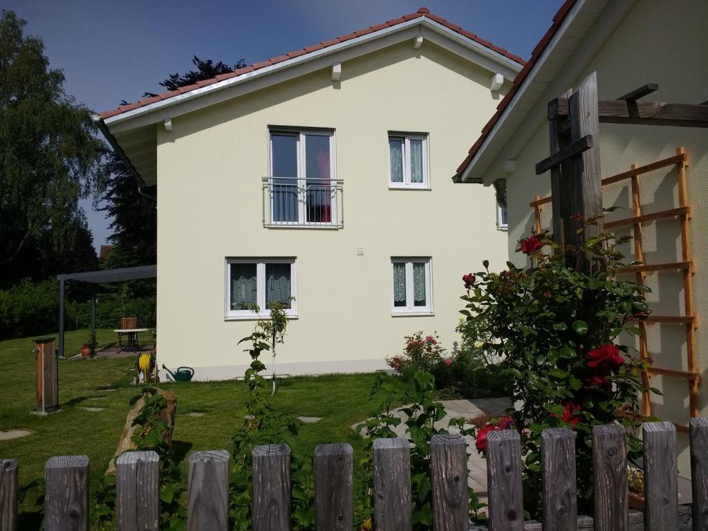 ein weißes Haus mit einem Zaun davor in der Unterkunft sehr schöne Ferienwohnung in Ebersberg bei München in Ebersberg
