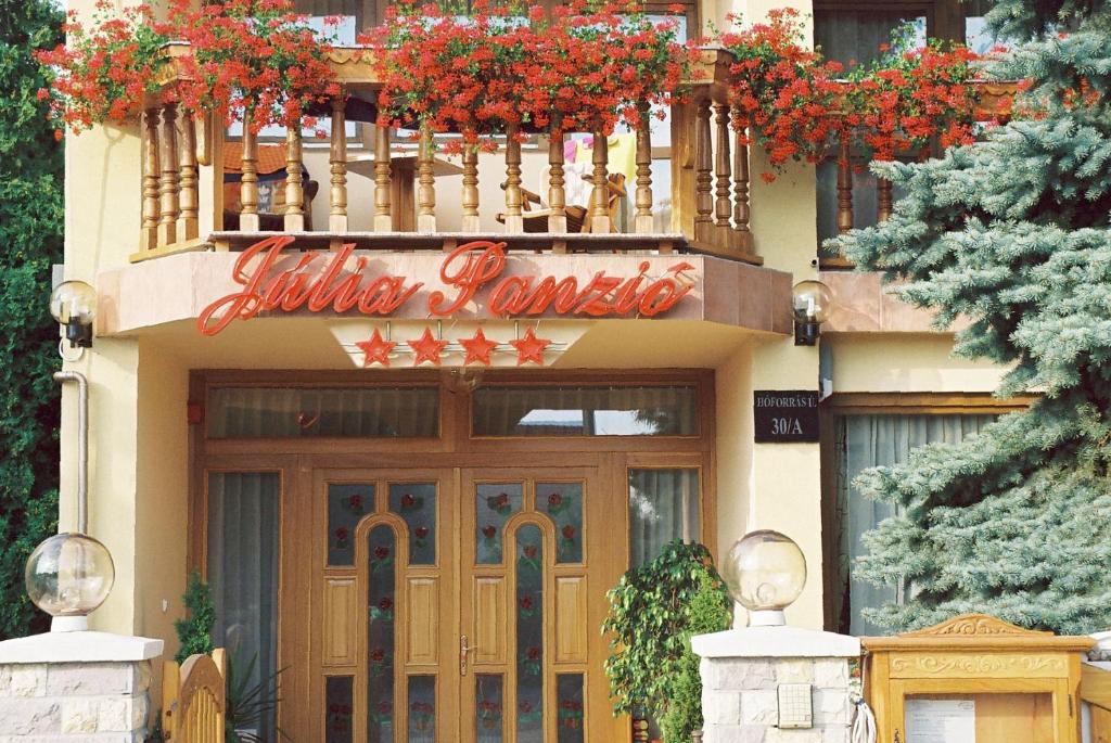 a building with a sign over the door of a restaurant at Júlia Panzió in Hajdúszoboszló