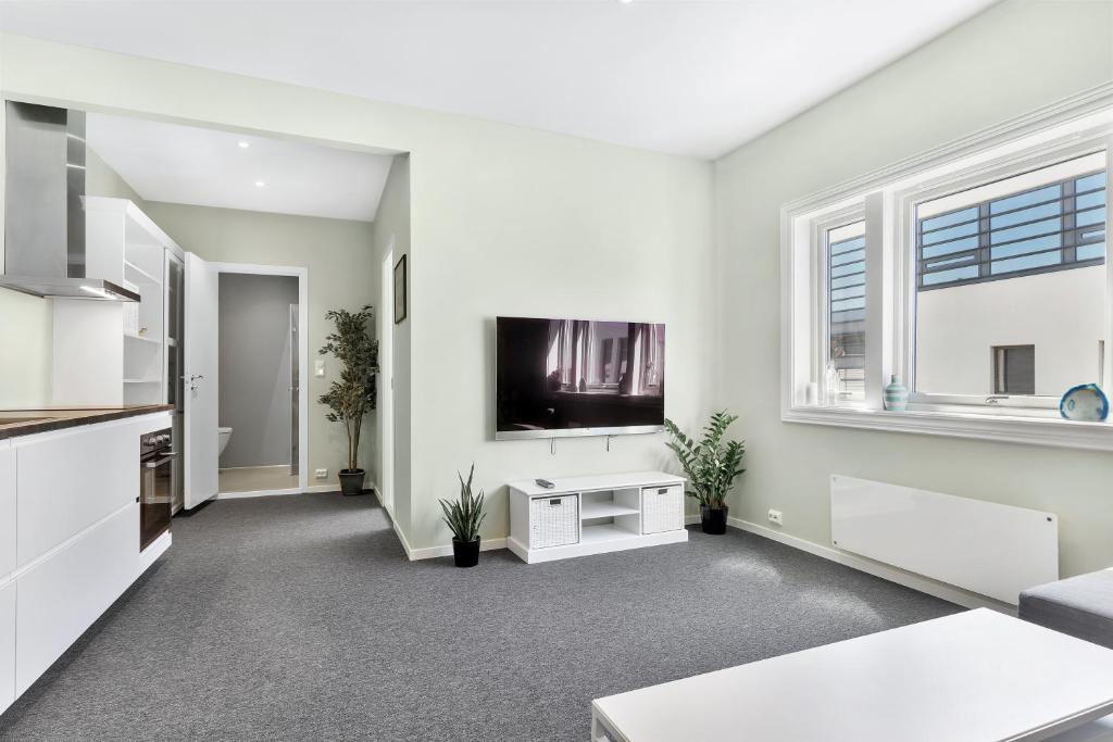 a white living room with a flat screen tv at Central Studio Apartment Apt 202 in Stavanger