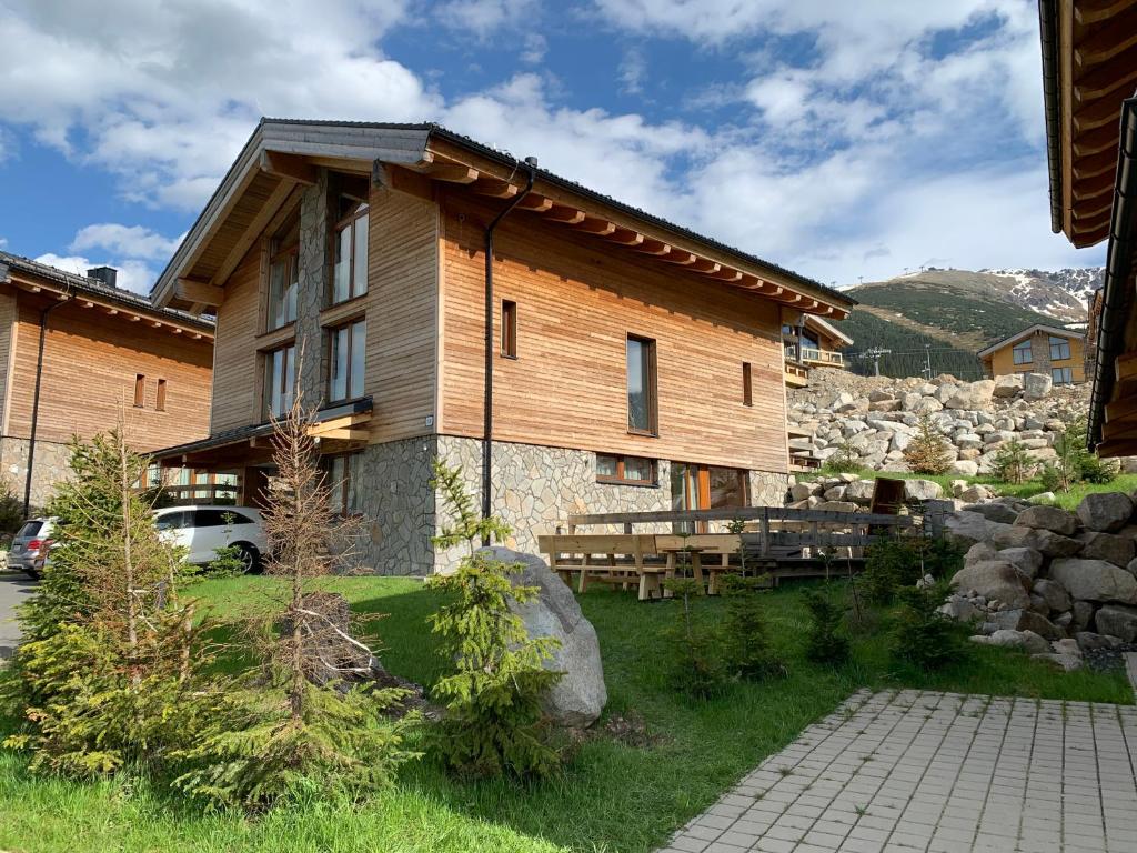 a large wooden house with a car parked in front of it at Challet Jasná Exclusive **** in Belá