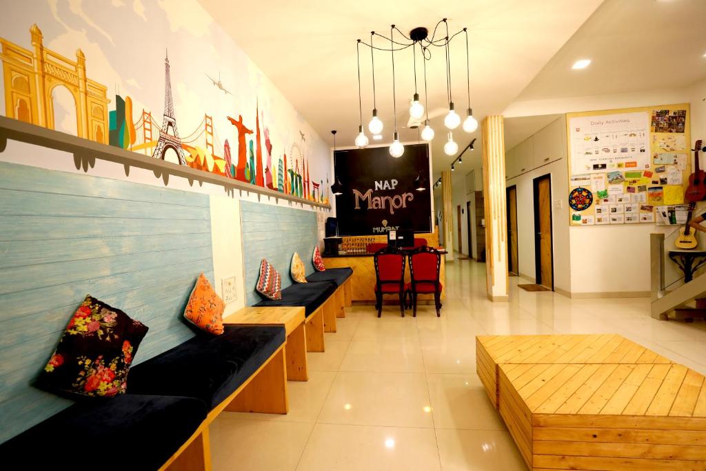 a store with couches and tables in a room at Nap Manor Hostels in Mumbai