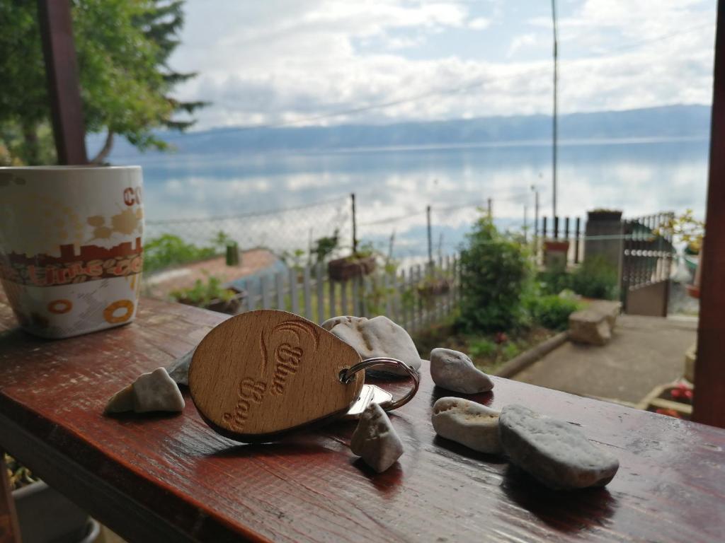 een houten tafel met een hartvormige tas en stenen bij Blue Bay Guest House in Trpejca