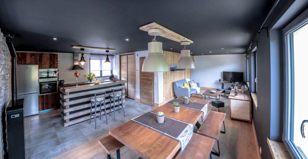 een keuken en een woonkamer met een tafel en stoelen bij Le petit coin de Jeanne et Marcel Maison de vacances La Bresse in La Bresse