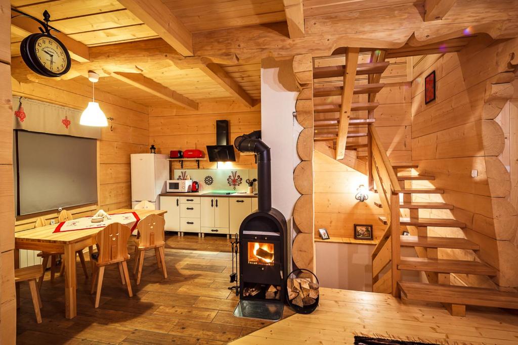 a kitchen and dining room with a wood stove at Domek Wierchowa in Zakopane