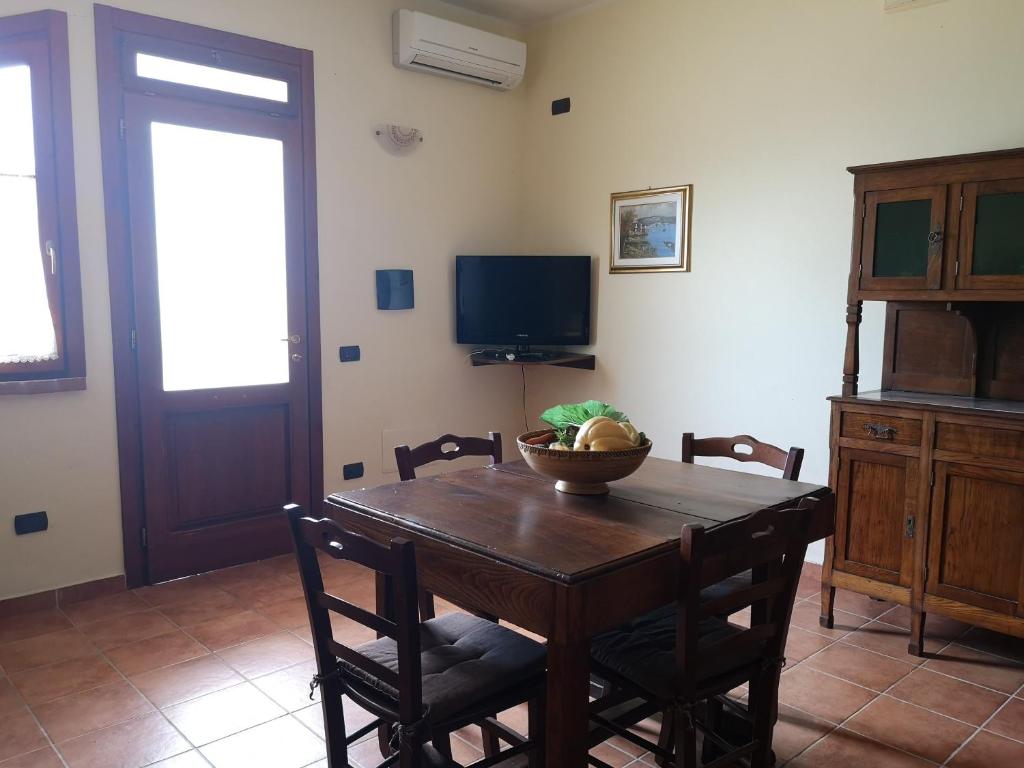 jadalnia ze stołem z krzesłami i telewizorem w obiekcie Agriturismo Catena w mieście Cirò