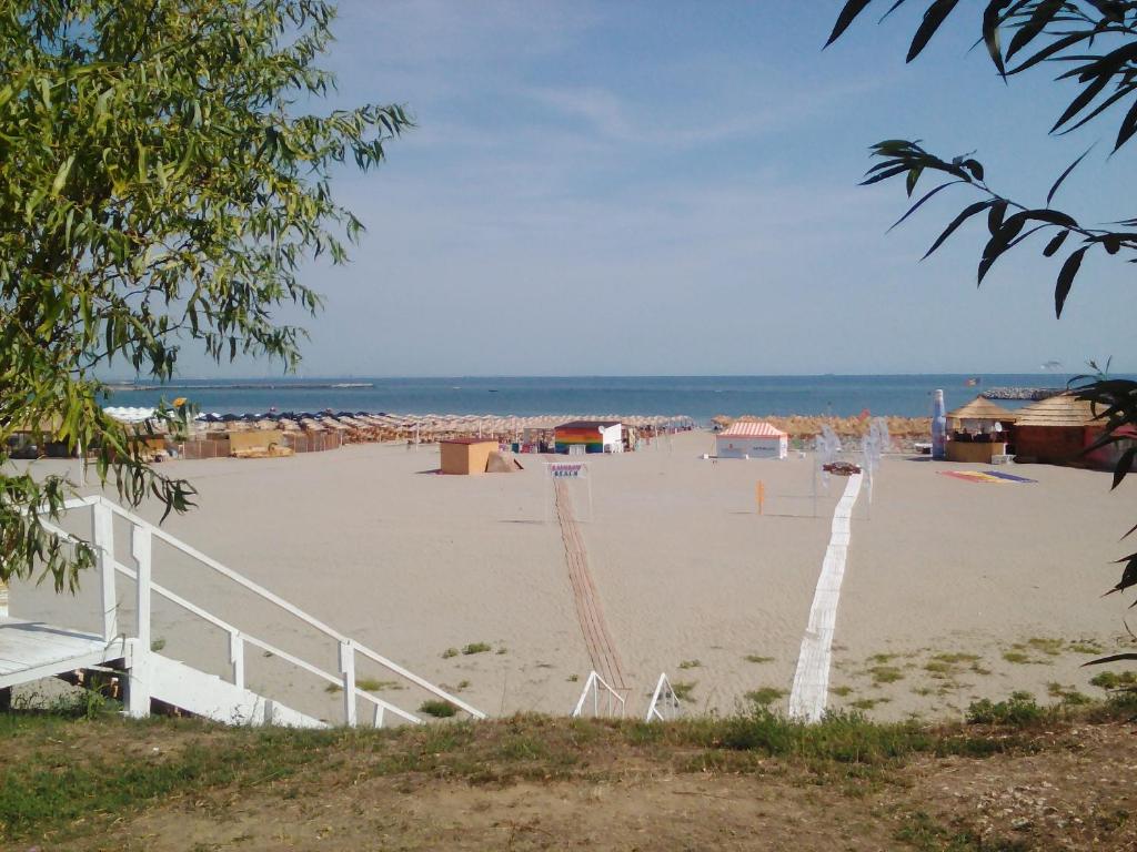 una playa de arena con un edificio y el océano en Apartament Ariadna Residence, en Constanţa