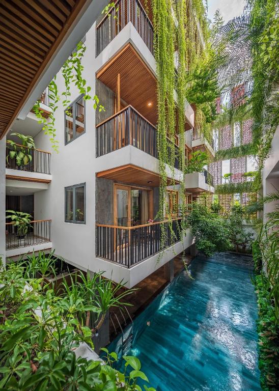 an indoor pool in the middle of a building with plants at Ponte Boutique Da Nang in Danang