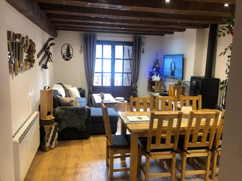 a dining room and living room with a table and chairs at Vall del Riu - Llar dolça llar in Soldeu