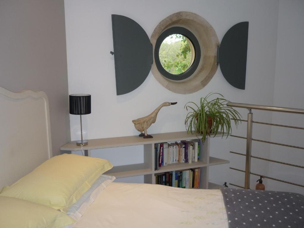 a bedroom with a bed and a round mirror at Hexagonal Tower for 2 with shared pool in Semur-en-Auxois