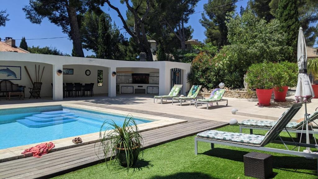 un patio trasero con piscina y una casa en Villa Serena, en La Ciotat