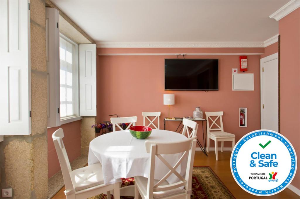 a dining room with a table and chairs and a tv at Oporto Centre Clean & Cozy Apt 1 in Porto