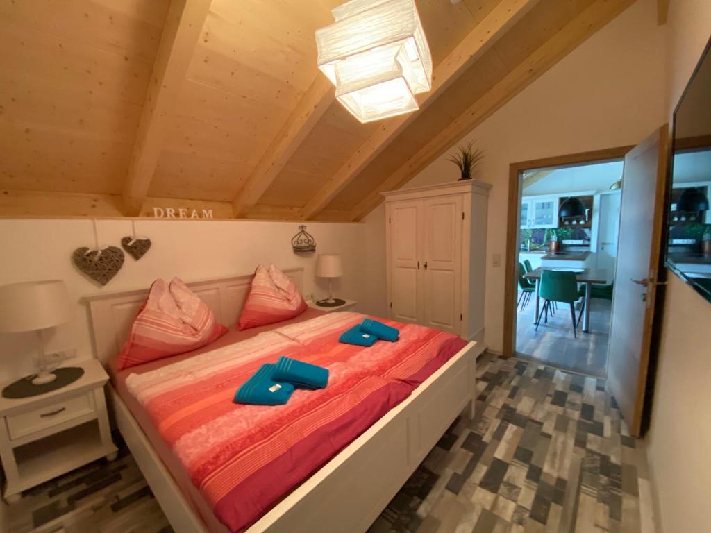 - une chambre avec un lit et des chaussons bleus dans l'établissement Apartments Edelweiß & Enzian - Gästehaus zum Fuchs, à Hermagor