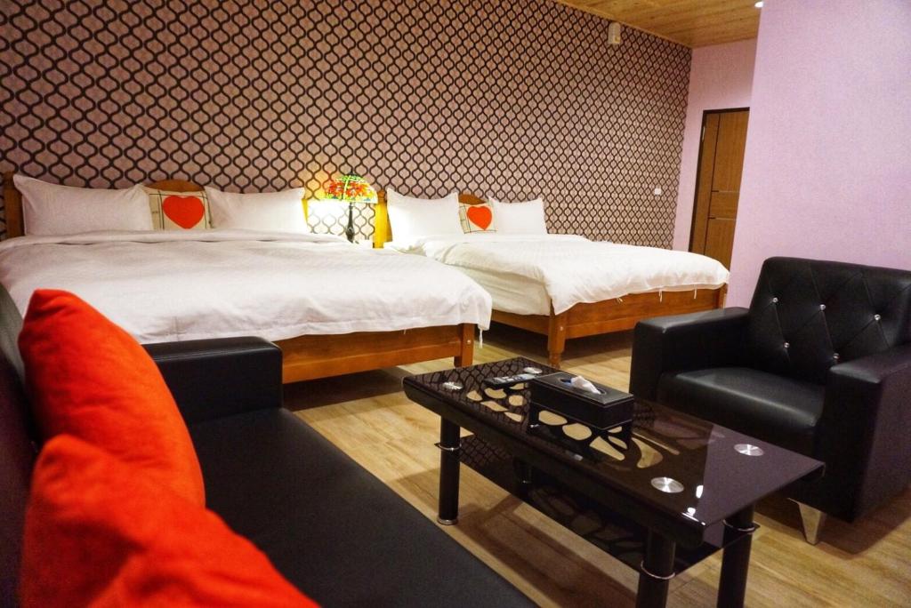 une chambre d'hôtel avec deux lits et un canapé dans l'établissement Chu Dream Hostel, à Hualien