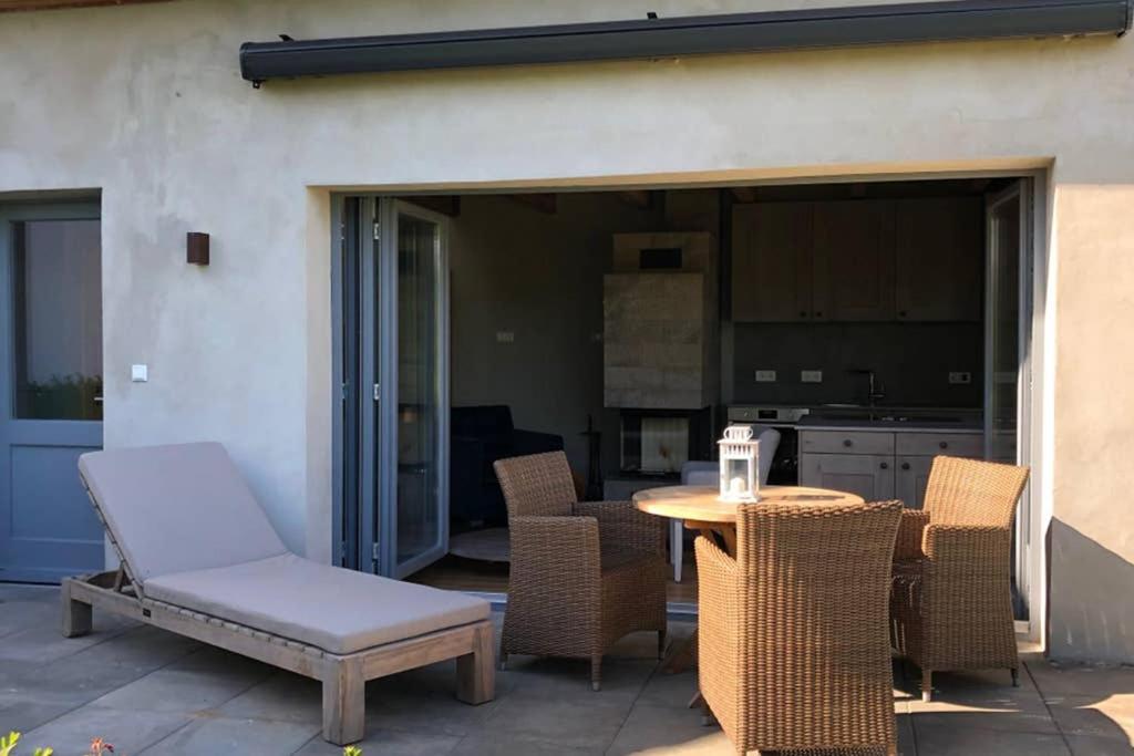 un patio avec une table et des chaises et une cuisine dans l'établissement Cottage@Baltic-Chalets, à Kalkhorst