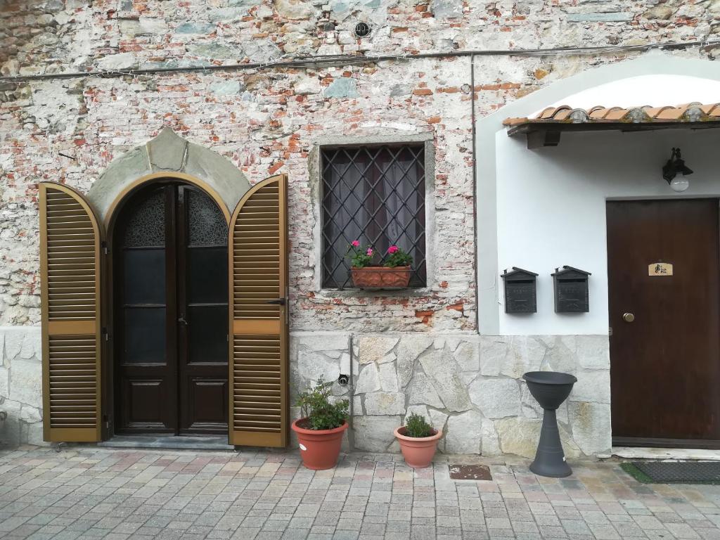 een gebouw met houten deuren en potplanten erop bij B&B A Casa Mia in Pisa