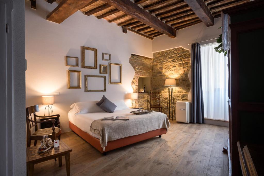 a bedroom with a bed and a table and chairs at Dimora delle Muse in Montalcino