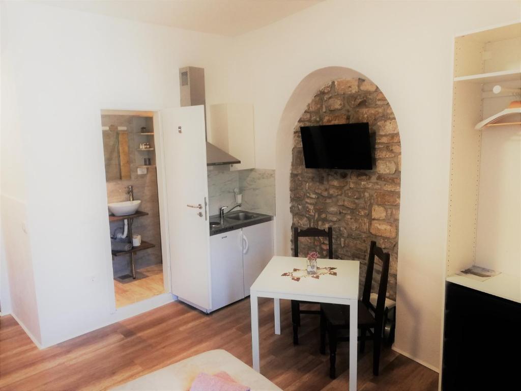 uma cozinha e sala de jantar com uma mesa branca num quarto em Apartments Primo Maggio em Piran