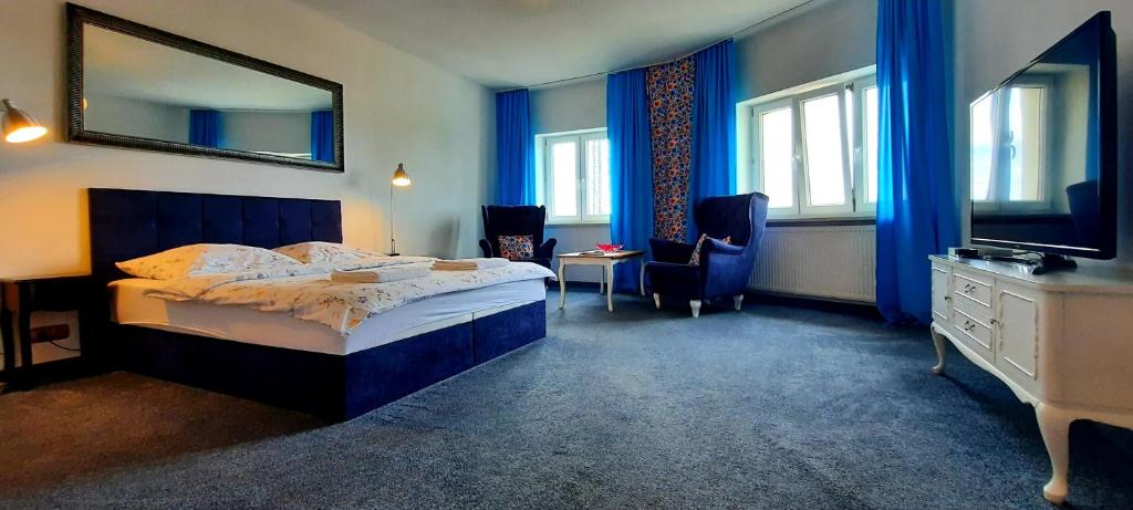 sypialnia z łóżkiem, biurkiem i telewizorem w obiekcie Apartamenty Sienkiewicza10 w mieście Łomża