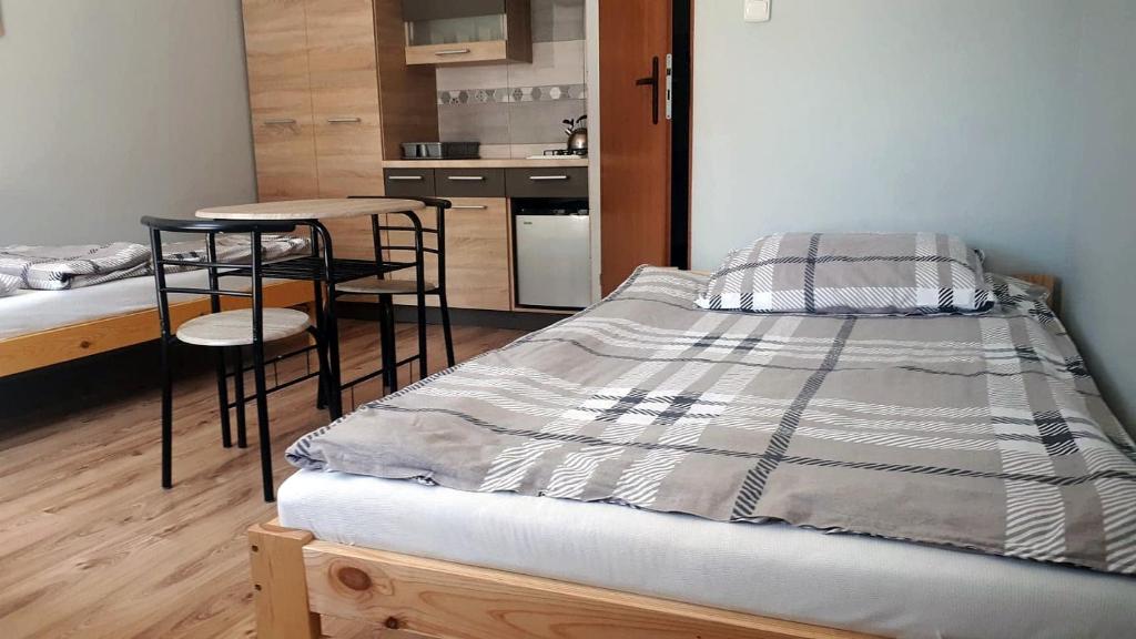 een slaapkamer met een bed en een kleine keuken bij Pokoje u Anastazji in Zakrzewo