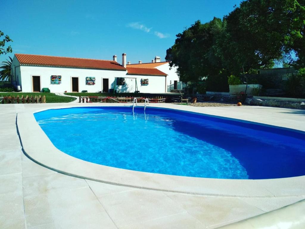 a blue swimming pool in front of a house at Pátio do Judeu in Valverde