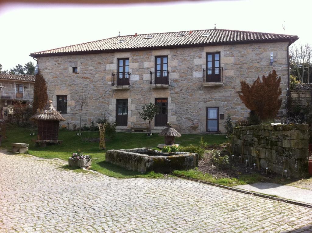 una grande casa in pietra con un cortile davanti di Casa das Augas Santas ad Aguas Santas