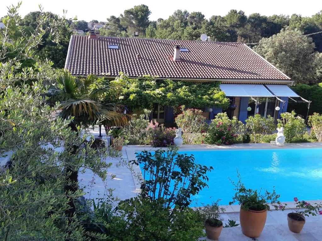 eine Villa mit einem Pool und einem Haus in der Unterkunft VILLA LA LICORNE Piscine privée, Jacuzzi, Massages, Tennis, Golf à 11km in Belcodène