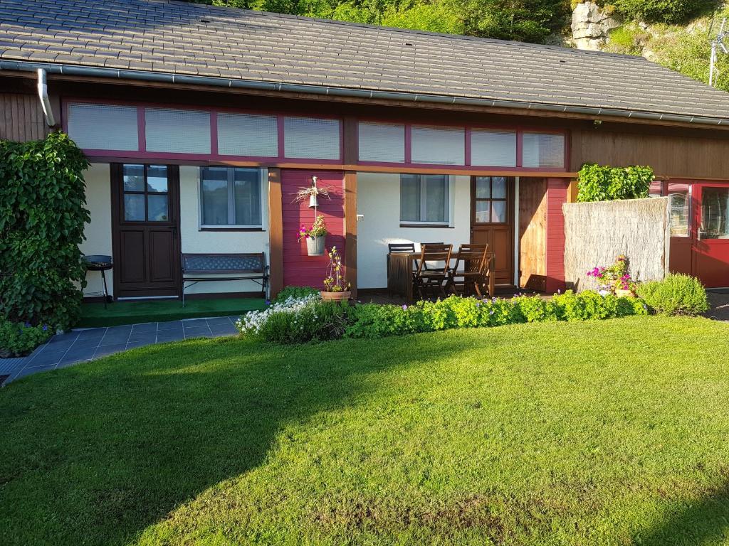 una casa roja y blanca con un patio de césped en Gîte tout confort 4 personnes en Besse-et-Saint-Anastaise