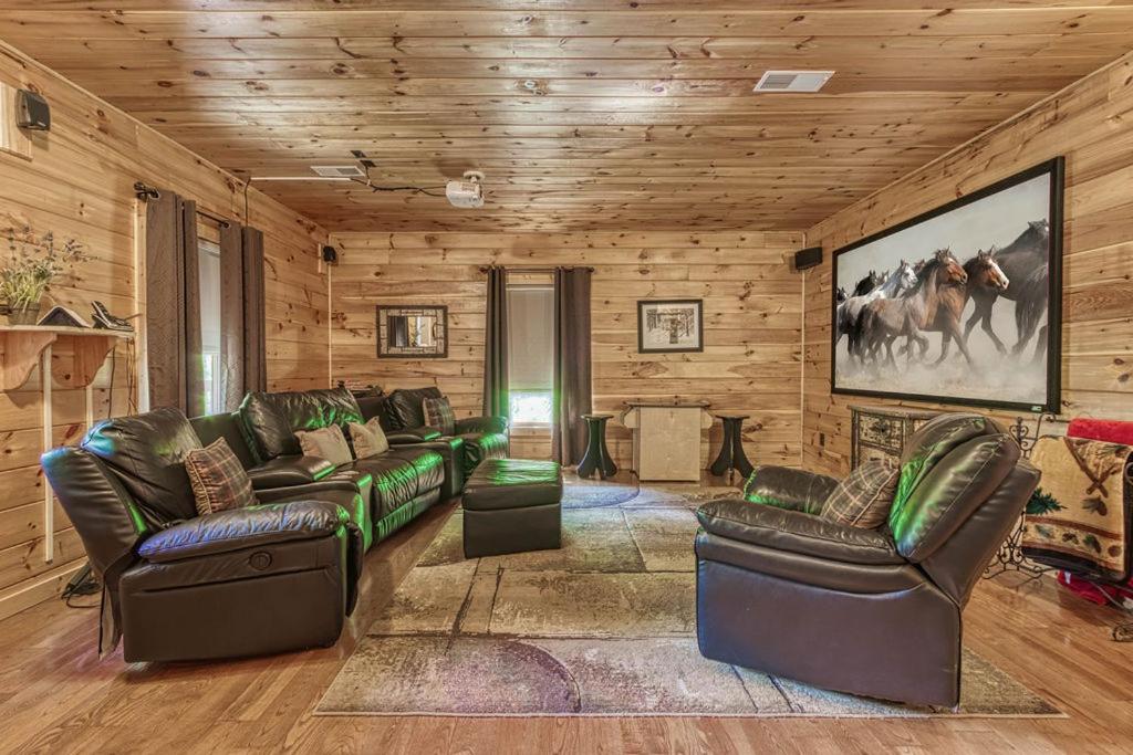 uma sala de estar com mobiliário de couro e paredes de madeira em Mountain Music em Sevierville