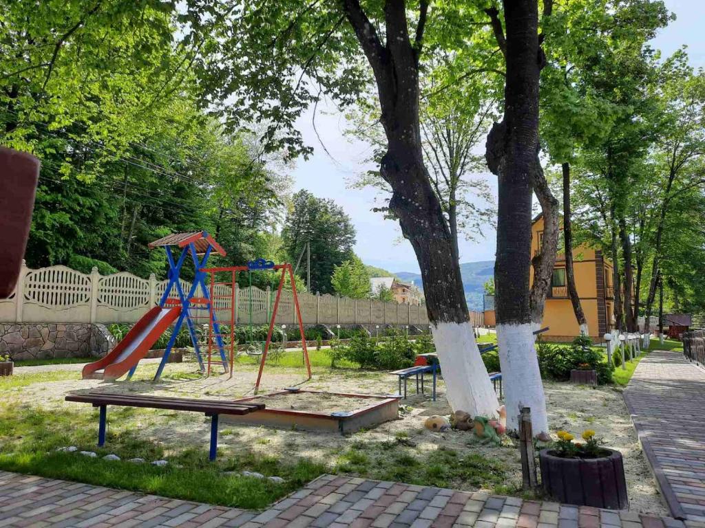 a playground with a slide and a swing set at Apartments in Polyana in Polyana