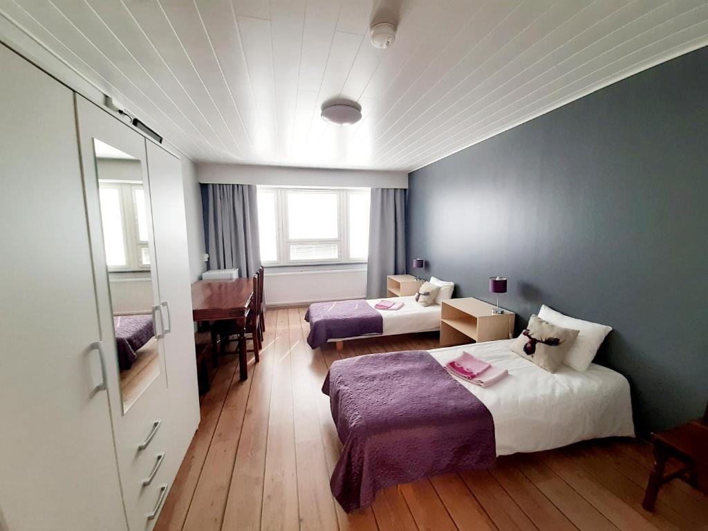 a hotel room with two beds and a window at Center Hostel Kaatrahovi in Lieksa