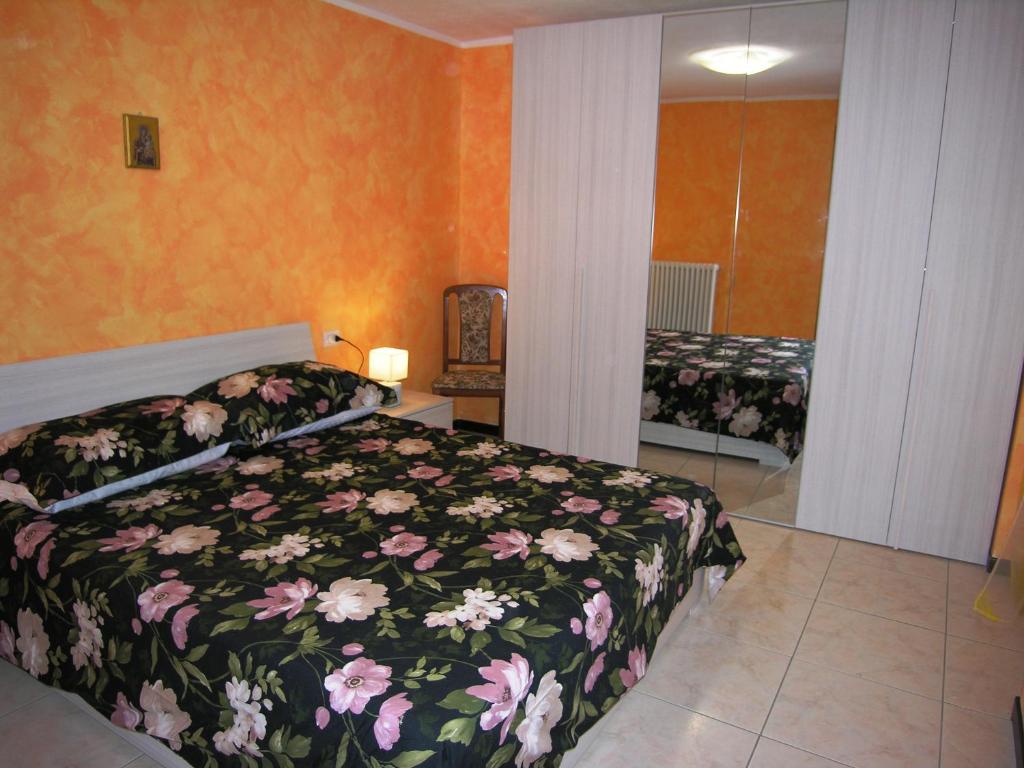 een slaapkamer met een bed met een bloemdekbed bij Casa Mary in San Siro