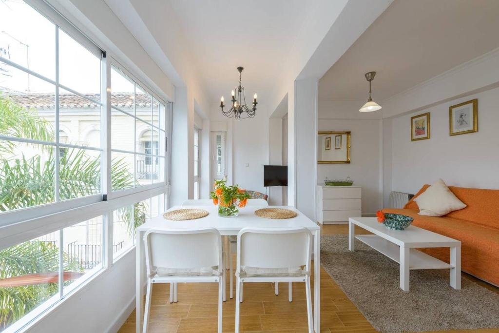 a living room with a table and chairs and a couch at Unique Plaza Higuitos in Almuñécar