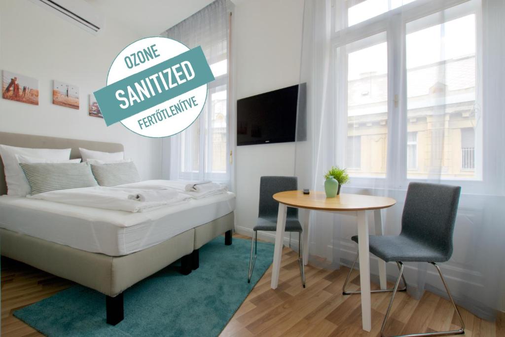 um quarto com uma cama e uma mesa e um sinal que lê transporte sorridente em Standard Apartment by Hi5 - Anker 1 em Budapeste