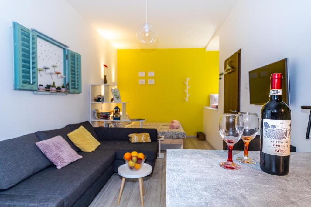 a living room with a bottle of wine and two wine glasses at Studio Apartman Baronessa Adriana in Rijeka
