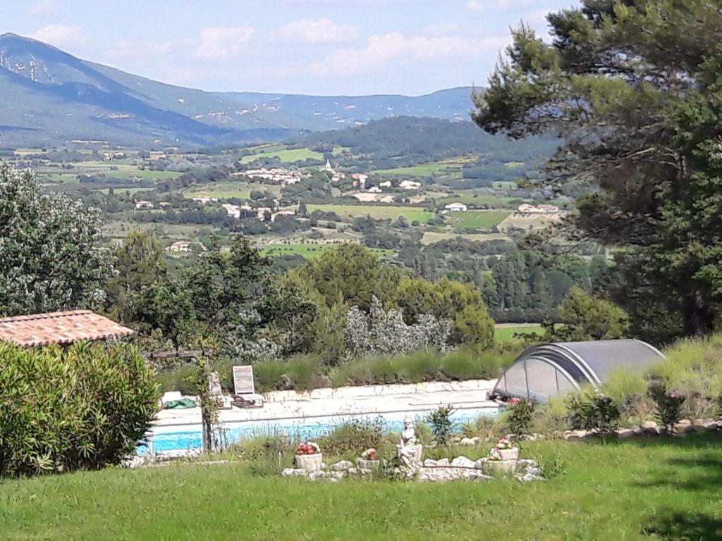 uitzicht op een zwembad met bergen op de achtergrond bij Les Cerises in Saint-Saturnin-dʼApt