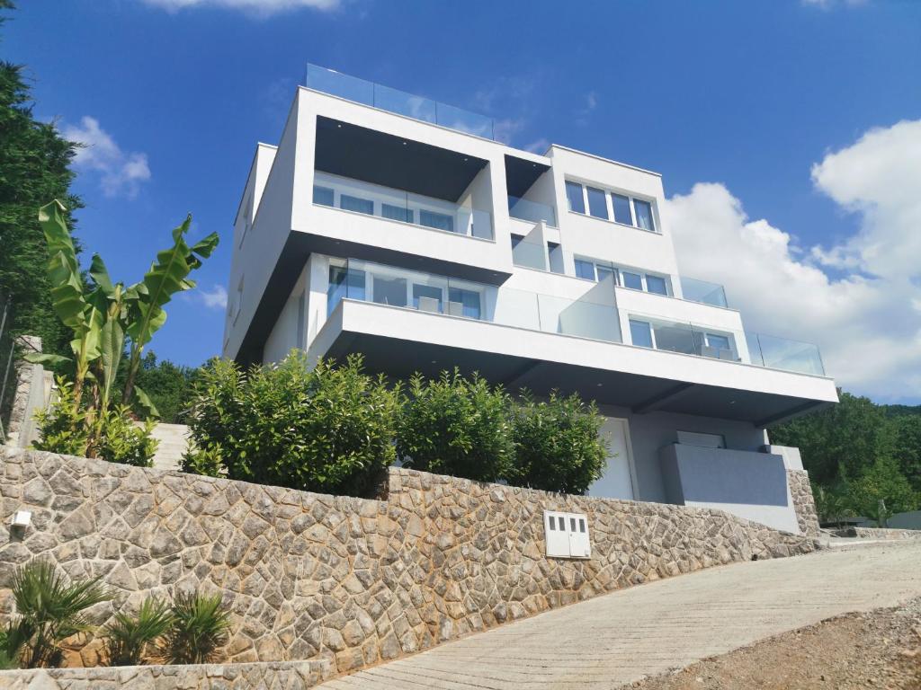 a large white building with a stone wall at Villa Isabela in Ičići