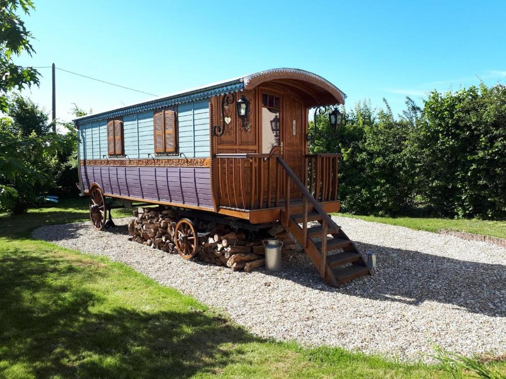 une petite voiture de train assise sur le gravier dans l'établissement La roulotte de Glorit, à Bourg