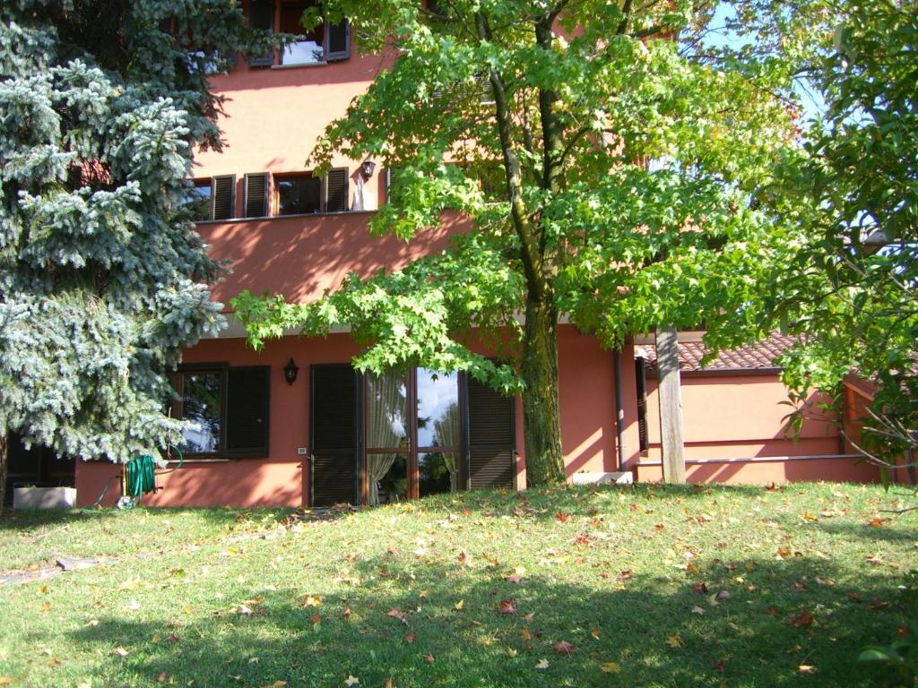 BogognoにあるRelais Cà Nova Guest Houseの木々が目の前に立つピンクの建物