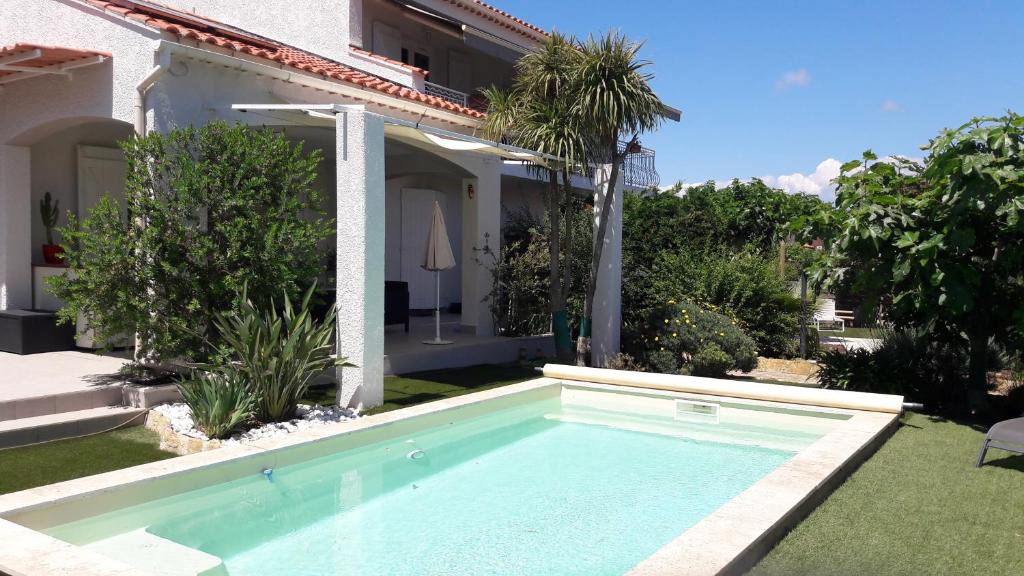 a swimming pool in the yard of a house at Villa Citronnelle in Six-Fours-les-Plages