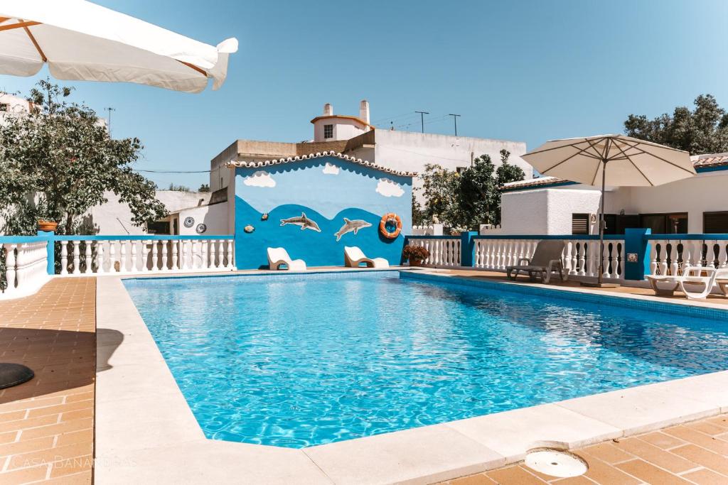 una piscina en un hotel con un mural de delfines en Casa Bananeiras, en Armação de Pêra