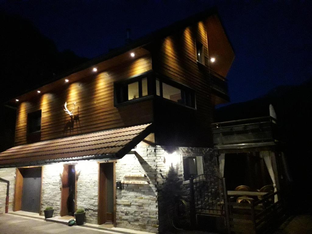 a house with lights on the side of it at night at Gîte Le Cerf de Belledonne in Sainte-Agnès